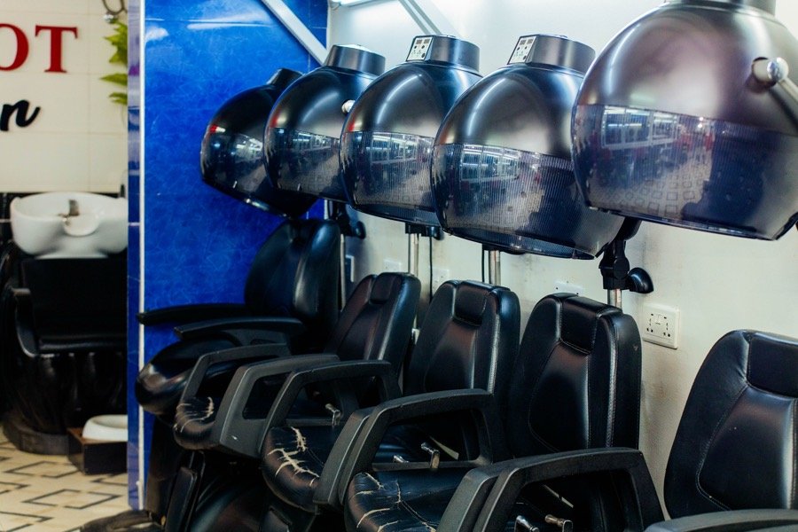 Black shampoo wash chairs beneath the Hairpot Salon sign