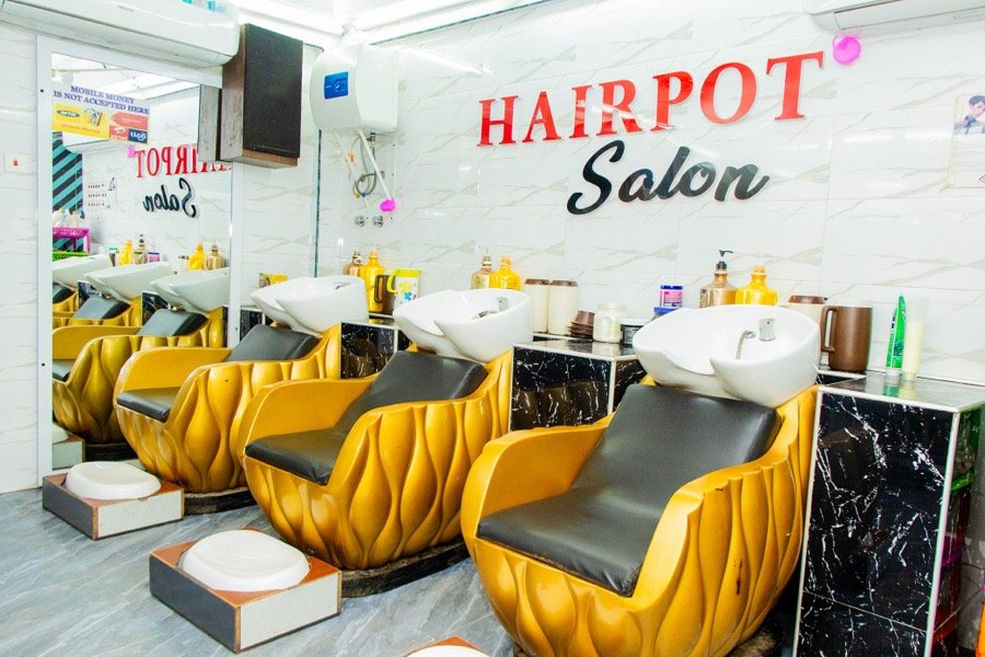 Row of gold-toned wash chairs beneath the Hairpot Salon sign