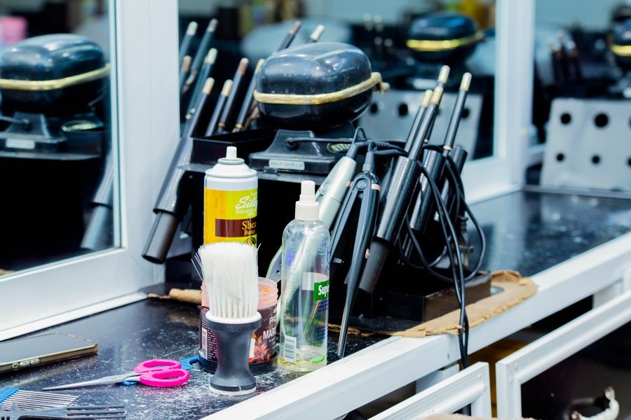 Scissors, brush, and grooming spray laid out at a styling station