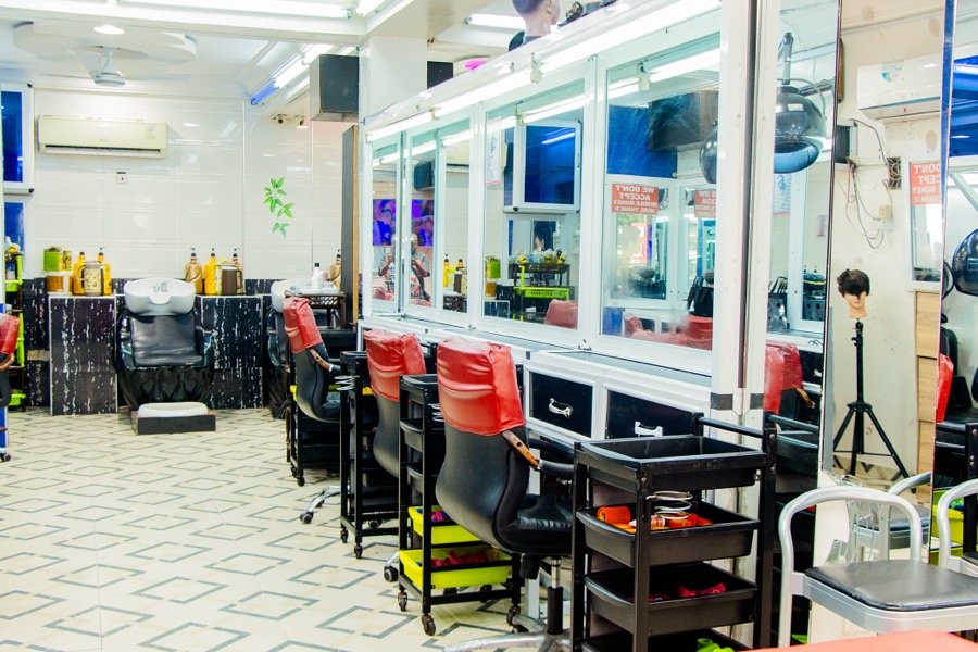 Styling counter with rolling chairs at a dark-toned station